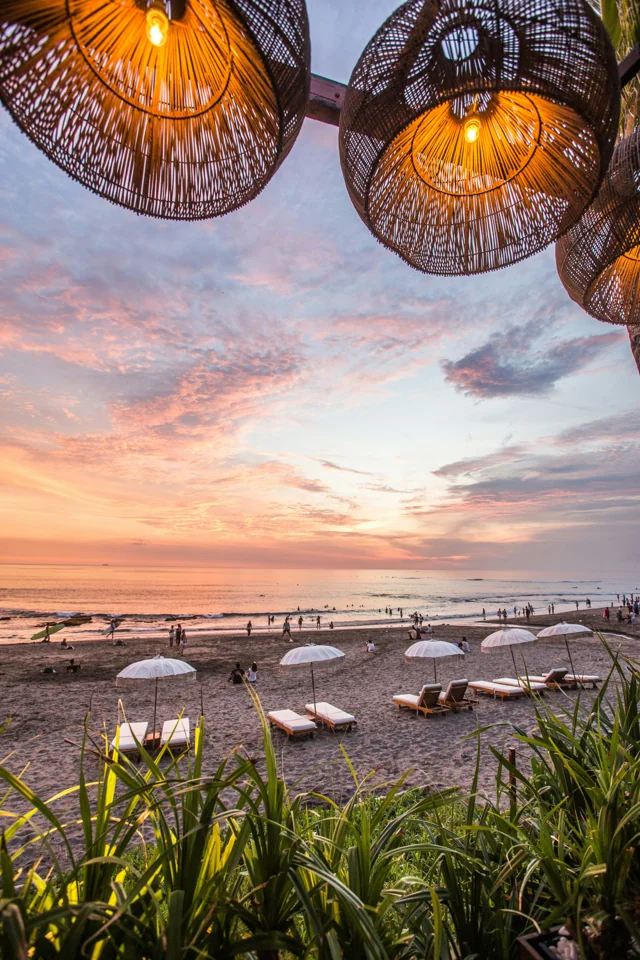 Tramonto sulla spiaggia, con lampade intrecciate in primo piano