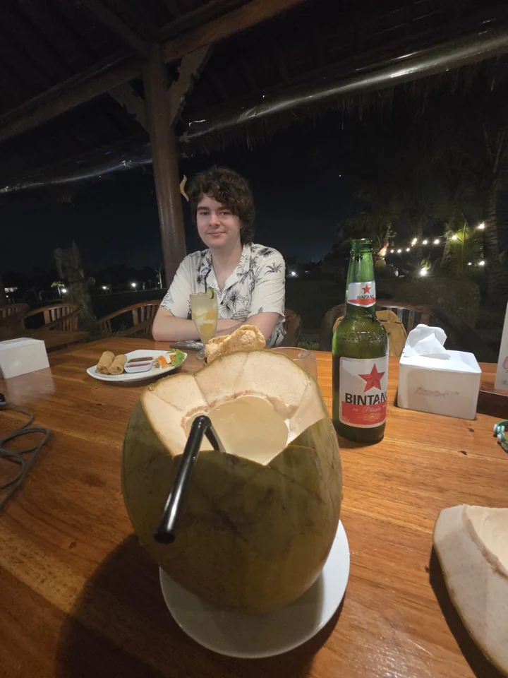 Un viaggiatore a tavola con cibo e una noce di cocco fresca