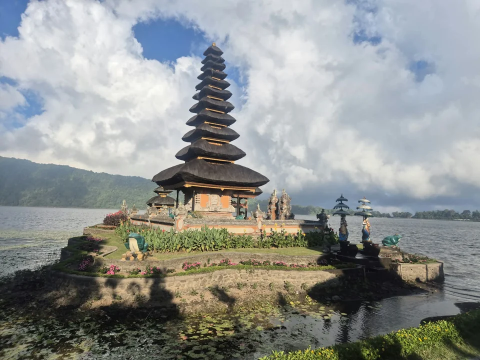 Un tempio vicino a un lago, con montagne sullo sfondo